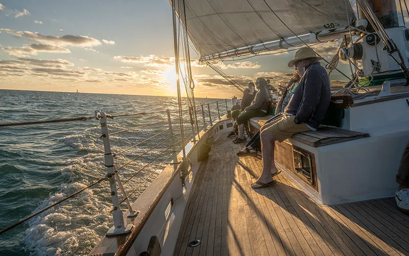 KeyWest_Champagne-Sunset_Slider-9 group of people enjoying a sunset view board the schooner america 2.0