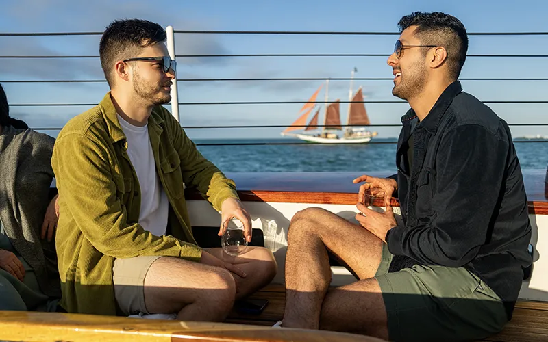 Sunset7 Two men having a conversation in the cockpit of Schooner America 2.0 for a sunset sail in Key West